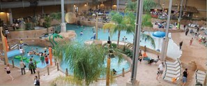 An indoor water park with multiple pools, slides, and a sandy area with lounge chairs. - Perfect Getaway In The Poconos! (House #1) HotTub !! Gameroom!! WiFi !! (Albrightsville)
