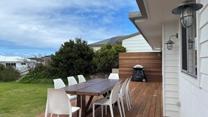 Une terrasse avec une table et des chaises, un barbecue et une vue sur les environs.