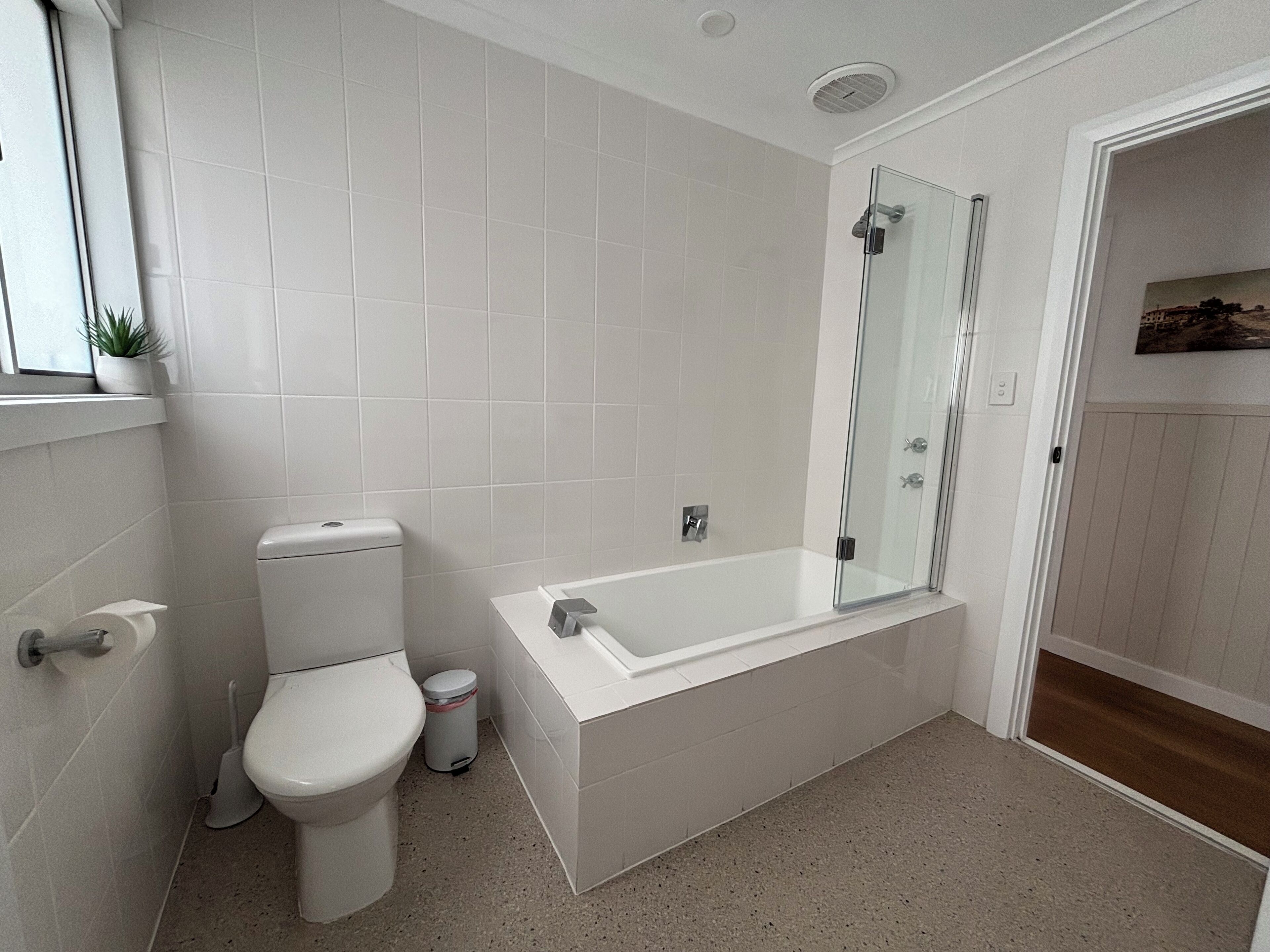 Une salle de bain moderne équipée de toilettes, d’un bidet et d’une douche à parois de verre.