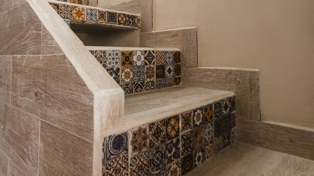 Un escalier avec des carreaux décoratifs et des marches en bois.