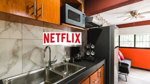 Une cuisine équipée d’un évier à deux bacs, de meubles en bois, d’un four à micro-ondes et d’un réfrigérateur.