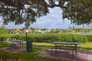 A park with picnic tables and benches, a pathway, and a view of houses and a body of water. - Newly Refurnished Tropical Townhouse - Watch Dolphin in the Bay, Fish from the Docks! Unit B62 (Siesta Key)