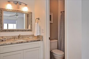 A bathroom with a marble sink, a large mirror with a decorative frame, a towel ring, and a toilet. - Newly Refurnished Tropical Townhouse - Watch Dolphin in the Bay, Fish from the Docks! Unit B62 (Siesta Key)