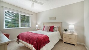 A bedroom with a bed, bedside tables, a ceiling fan, and a window with blinds. - Sprinkle of Irish charm, beautifully updated, Siesta Dunes 8-205 (Siesta Key)