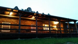 Ein rustikales Holzgebäude mit überdachter Veranda und Backsteinmauern.