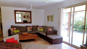 A living room with a sofa set, a coffee table, and a chair. - Island Time Villas - Villa Kakaia (Muri Beach)