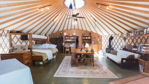 A yurt with a central seating area, a dining table, and a kitchen area. - Private Pickleball Ct - Indoor Hot Tub - Spa Room - Lift Tkts  (Windham)