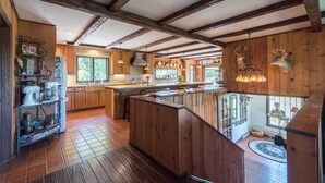 A spacious kitchen with wooden beams, a central island, and a view of the outdoors. - Private Pickleball Ct - Indoor Hot Tub - Spa Room - Lift Tkts  (Windham)