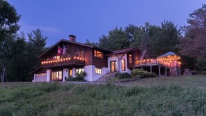 A two-story house with a balcony and a covered porch, surrounded by greenery. - Private Pickleball Ct - Indoor Hot Tub - Spa Room - Lift Tkts  (Windham)