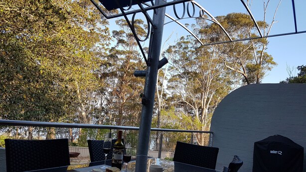 An outdoor dining area with a table set for two, including plates of food, cutlery, and a bottle of wine. - Seahorse - Avellino filtered  Sea views- Long Beach (Long Beach)