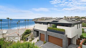 Una moderna casa a due piani con vista sull'oceano e sulla spiaggia.
