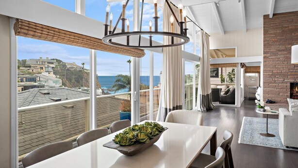 Un interno moderno con zona pranzo, cucina e soggiorno vista oceano.