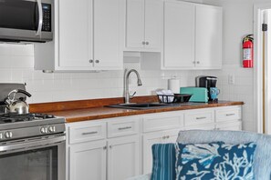 A kitchen with white cabinets, a stainless steel stove, a sink, and a microwave. - SEA HEAR NOW STAY....... SEPTEMBER IS PERFECT BEACH WEATHER ENJOY YOUR TIME HERE (Seaside Heights)