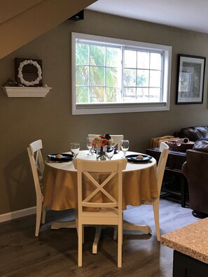 A dining area with a table set for four, a window with a view of greenery, and a framed picture on the wall. - ✻Beautiful & Spacious Oside Oasis Family Retreat✻ (Oceanside)