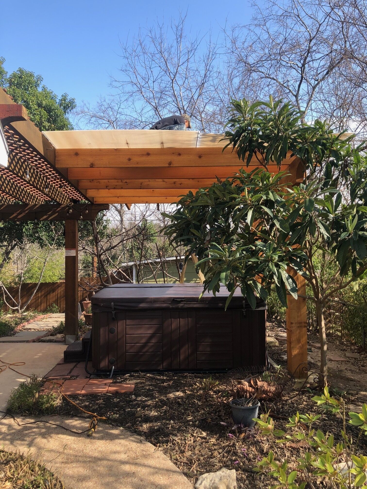 Een houten pergola met een hottub eronder.