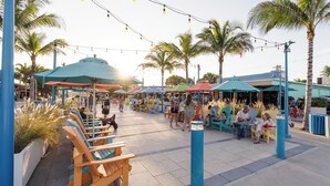 Outdoor seating with umbrellas, palm trees, and string lights. - UNIT # 7 Ocean and Downtown view LAUDERDALE BY THE SEA  200+- steps to beach fun (Lauderdale-by-the-Sea)