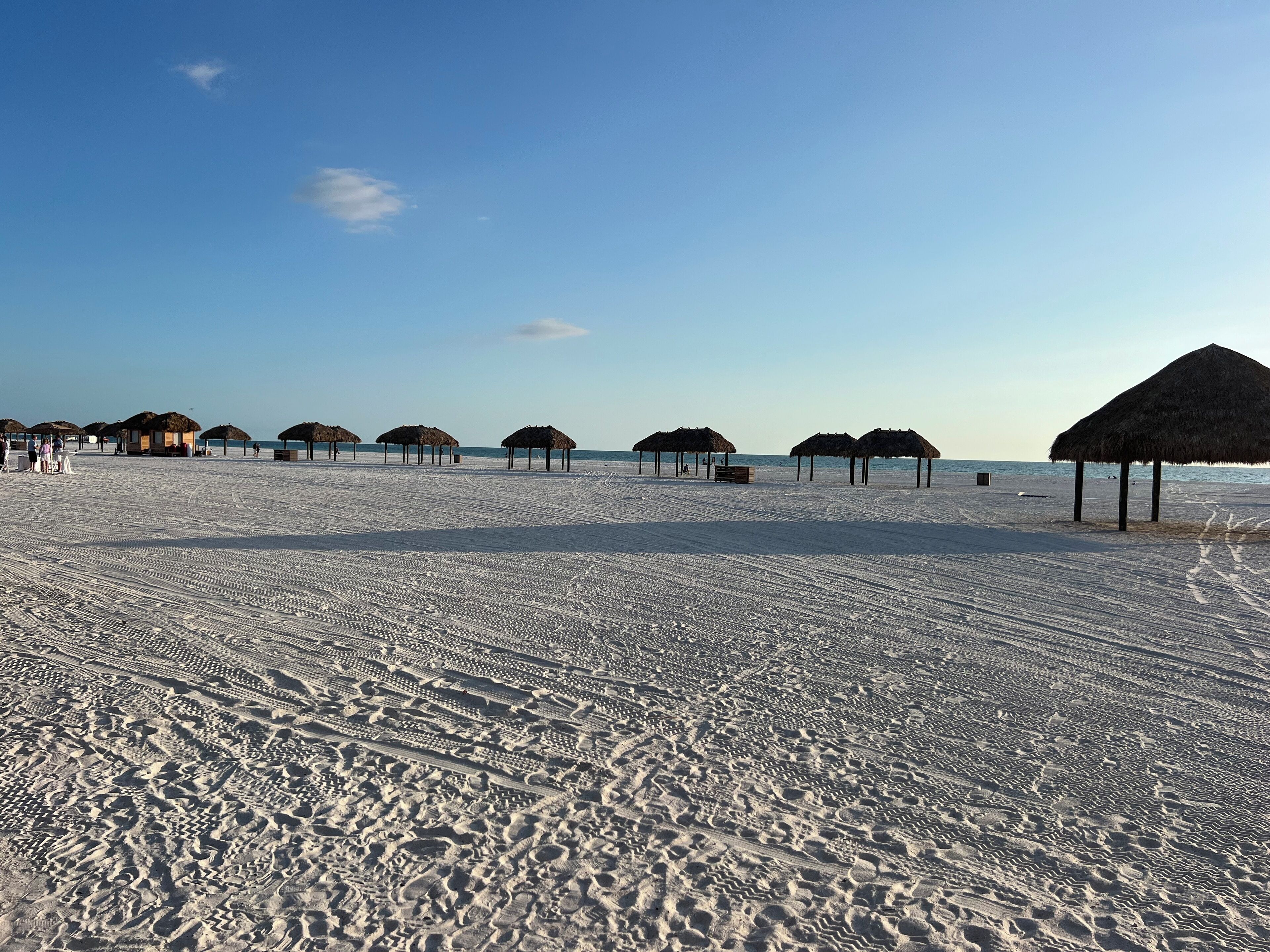Uma praia com construções de palha e areia.
