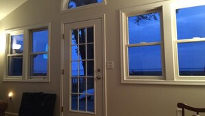 Une pièce dotée d’une grande fenêtre, d’une porte à panneaux de verre et offrant une vue sur le ciel.