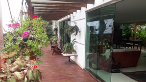 A wooden deck with potted plants and a glass wall. - Tranquility on the right side of Ferradura (Buzios)
