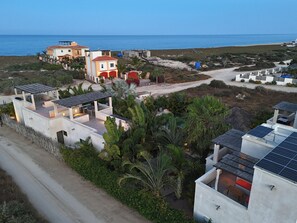 A coastal residential area with modern houses, solar panels, and a view of the sea. - Vista Tortuga Ocean View VILLA-AZUL Heated Pool by the BEACH (Todos Santos)