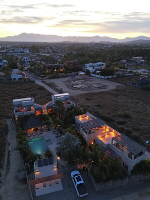 A residential area with modern houses, a swimming pool, and a car parked in the driveway. - Vista Tortuga Ocean View VILLA-AZUL Heated Pool by the BEACH (Todos Santos)