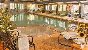 An indoor swimming pool with lounge chairs and sunflowers.