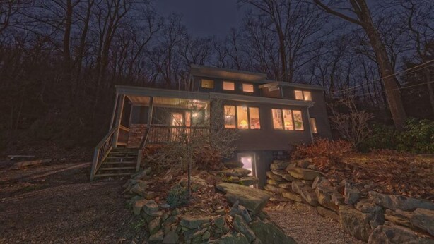 A modern two-story house with a stone pathway leading to the entrance.