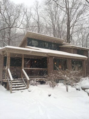 A two-story house with a covered porch and a staircase leading to the entrance.