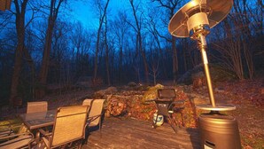 A deck with outdoor furniture, a trash can, and a solar panel.