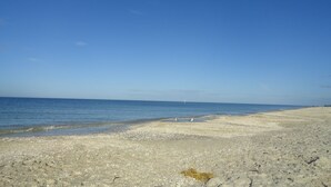 Una playa con cielos despejados y agua tranquila.