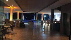 Un espacio interior amplio con arreglos de asientos y un mostrador de recepción.