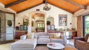A spacious living room with a large sectional sofa, a coffee table, and a kitchen in the background. - Secluded Vineyard Estate Healdsburg (Healdsburg)