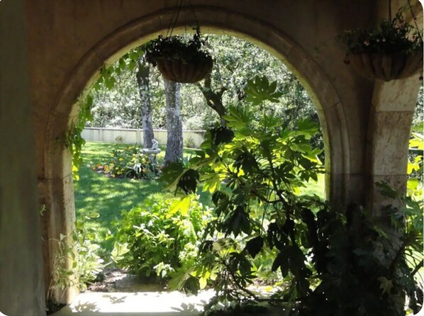 An arched doorway leading to a garden with a hanging planter and a tree. - Secluded Vineyard Estate Healdsburg (Healdsburg)