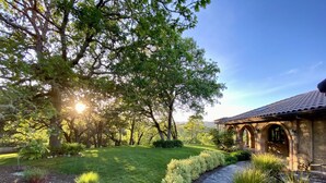 A well-maintained garden with a stone pathway leading to a building with arches. - Secluded Vineyard Estate Healdsburg (Healdsburg)