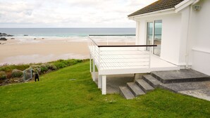 Un bâtiment blanc doté d’un balcon donnant sur une plage.