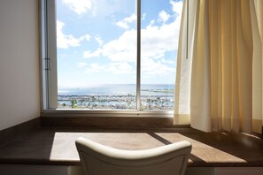 Una habitación con un ventanal grande que da a un puerto deportivo y al océano.