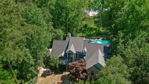 A house surrounded by dense trees, a swimming pool, and a small deck area. - Waterfront Retreat w/ Pool, Hot Tub, Dock & Sand Beach. Relax & enjoy the Rivah! (Lancaster)