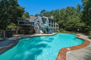 A swimming pool with a brick border, a covered patio area, and a large house with a porch and stairs. - Waterfront Retreat w/ Pool, Hot Tub, Dock & Sand Beach. Relax & enjoy the Rivah! (Lancaster)
