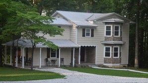 A two-story house with a covered porch and a stone facade.