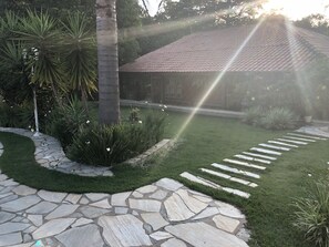 A stone pathway leading to a building with a tiled roof, surrounded by lush greenery and a well-maintained lawn. - Farm 40 minutes from SP near Itu and Sorocaba, leisure for adults and children (Itu)