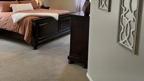 A bedroom with a bed, a nightstand, a dresser, a ceiling fan, and decorative wall art. - Oasis Pool and Backyard!  Johnson Ranch Golf Course  (San Tan Valley)