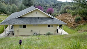 Una casa de un piso con techo inclinado, un porche cubierto y una antena parabólica.