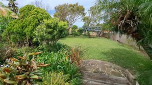 A well-maintained garden with a variety of plants and a wooden deck.
