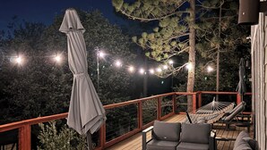 En terrasse med udendørs møbler, lyskæder og en hængekøje.