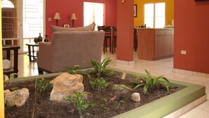 Un salon avec un canapé, une table basse et un petit jardin d’intérieur.