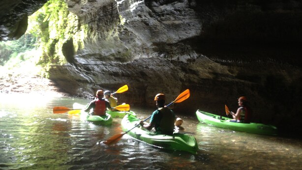 Un groupe de personnes pratiquant le kayak dans une grotte.