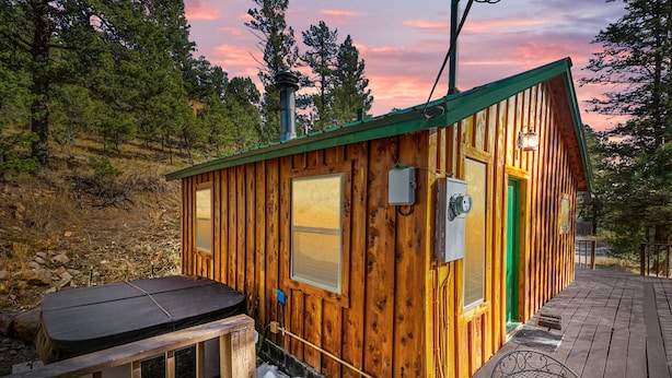 A wooden cabin with a green door, a hot tub, and a deck. - Mountain-side Cabin with hot tub! Close To Town And Skiing on 1.1 acres.  (Ruidoso)
