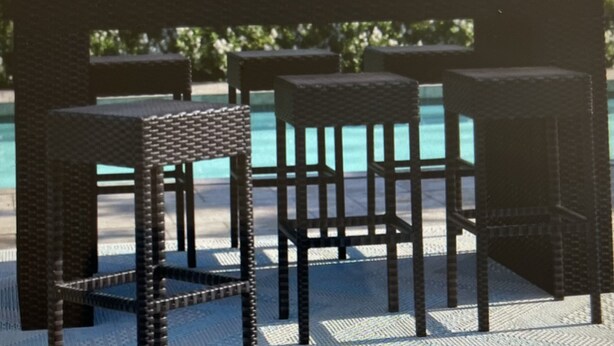 A poolside area with wicker chairs and a table. - Beautiful Free-Standing Cottage, In The Heart of Provincetown.  (Provincetown)