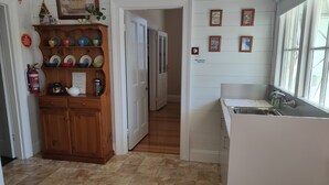 A kitchen with a wooden cabinet, a sink, and a window. - Hawthorn House Launceston (Invermay)