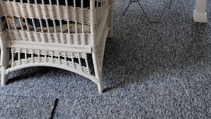 A room with a wicker chair, a folding chair, a television, and a window with blinds. - Immaculate Cottage, Huge Deck And Great Back Yard For All Your Yard Games. (Middletown)